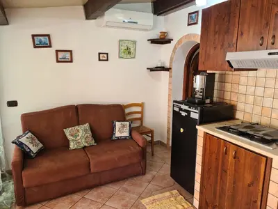 a living room with a brown couch in a kitchen at Holiday House Giorgia in Terrasini