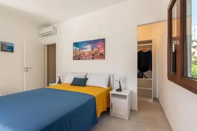 a bedroom with a blue and yellow bed and a window at Villetta Hilda by Wonderful Italy in Mondello