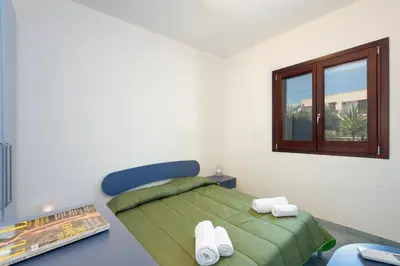 a bedroom with a green bed and a window at Paprica&Zenzero in San Vito lo Capo