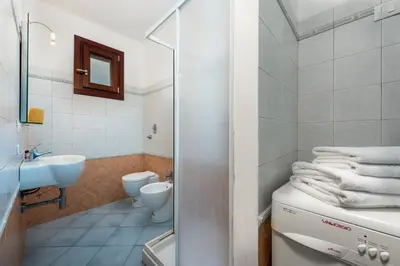 a white bathroom with a sink and a toilet at Paprica&Zenzero in San Vito lo Capo