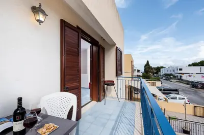 a balcony with a table and a view of a street at Paprica&Zenzero in San Vito lo Capo