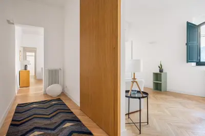 a living room with a wooden door and a rug at Casa Mirto a Piazza Marina by Wonderful Italy in Palermo