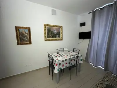 a dining room with a table and chairs and paintings on the wall at Capobeb in Palermo