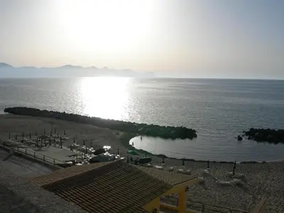 a view of a beach with the sun reflecting on the water at Case Vacanza Trappetodavivere in Trappeto