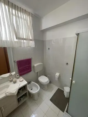 a white bathroom with a toilet and a sink at Case Vacanza Trappetodavivere in Trappeto