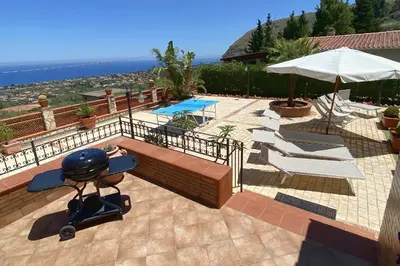 a patio with a grill and chairs and a pool at Villa Belvedere di Altavilla with Pool and Near The Sea in Altavilla Milicia