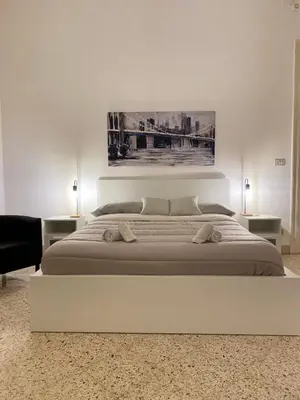 a white bedroom with a large bed with two lamps at Urban poet retreat - casa di vincenzo e andrea 2 in Palermo