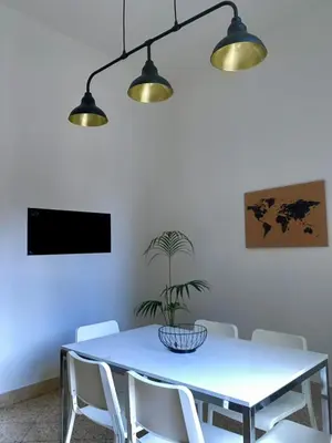 a dining room table with white chairs and a potted plant at Urban poet retreat - casa di vincenzo e andrea 2 in Palermo
