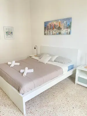 a white bed with two white towels on it at Urban poet retreat - casa di vincenzo e andrea 2 in Palermo