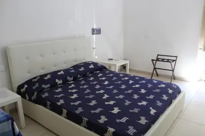 a bedroom with a bed with a blue blanket on it at La Melagrana in Castellammare del Golfo