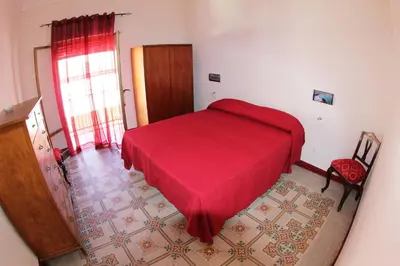 a bedroom with a red bed in a room at La Melagrana in Castellammare del Golfo