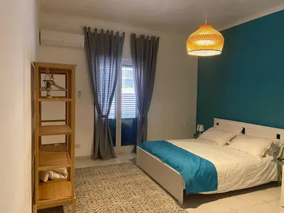 a bedroom with a bed and a blue wall at Cortile Cascino Home in Palermo