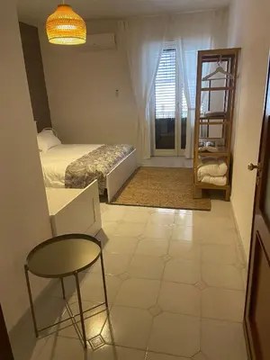 a room with a bed and a table and a chair at Cortile Cascino Home in Palermo