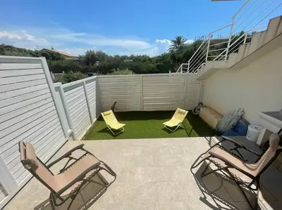 a patio with two lawn chairs and a fence at Sicilian Shore Haven, 2 min to SEA in Terrasini
