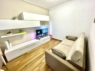 a living room with a couch and a flat screen tv at Sicilian Shore Haven, 2 min to SEA in Terrasini