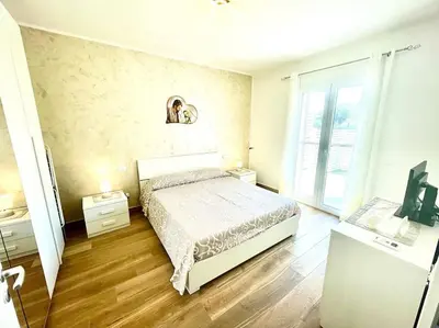 a bedroom with a bed and a tv in it at Sicilian Shore Haven, 2 min to SEA in Terrasini