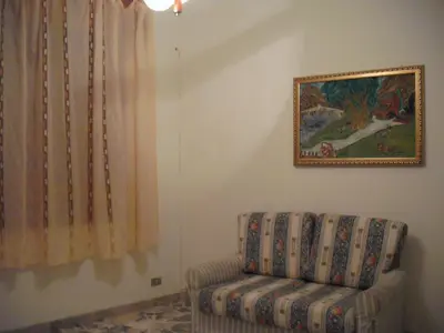 a living room with a chair and a painting on the wall at Calatafimi Segesta -Casa vacanze Appartamento Garibaldi in Calatafimi