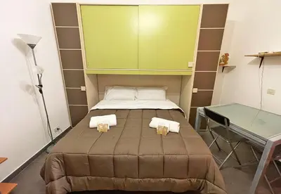 a small bedroom with a bed and a desk at Monfenera Little Apartments in Palermo