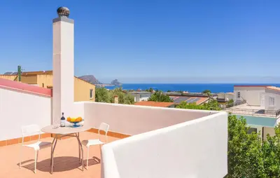a table and chairs on a balcony with a lighthouse at Beautiful Home In Altavilla Milicia in Altavilla Milicia