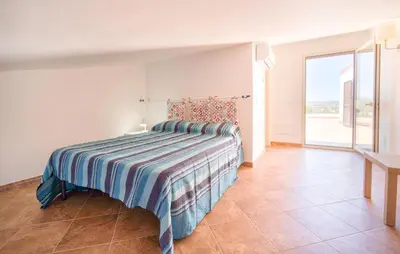 a bedroom with a bed with a striped blanket at Beautiful Home In Altavilla Milicia in Altavilla Milicia