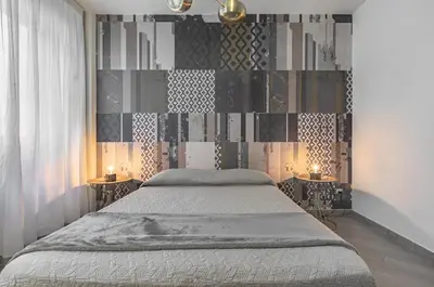 a bedroom with a bed and two side tables at GuestHost - Al Qasr Design and Luxury Flat - Palermo Center in Palermo