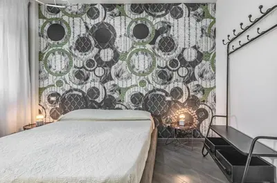 a bedroom with a large bed and a wall mural at GuestHost - Al Qasr Design and Luxury Flat - Palermo Center in Palermo