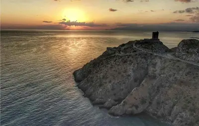 an island in the water with a sunset in the background at 2 Bedroom Amazing Home In Trabia in Trabia