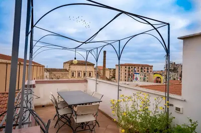 a table and chairs on a balcony with a view of a city at La Terrazza Sullo Spasimo in Palermo