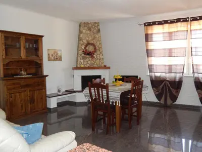 a living room with a table and chairs and a fireplace at Casa Vacanze Karol in Trappeto