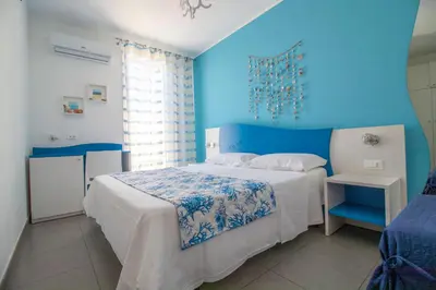 a blue bedroom with a bed and a blue wall at Hotel Arte Mare - camere in via del mulino 45 in San Vito lo Capo
