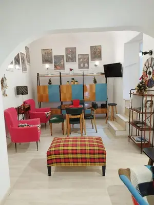 a living room with colorful chairs and a table at The tailor's house in Palermo