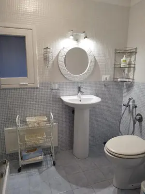 a bathroom with a sink and a toilet and a mirror at The tailor's house in Palermo