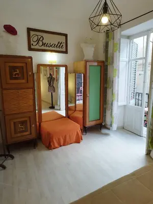 a room with mirrors and a bed and a dresser at The tailor's house in Palermo