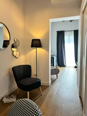 a living room with a chair and a lamp at Olivuzza 27 in Palermo