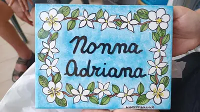 a person holding a sign that says namma adelaide at NONNA ADRIANA in Terrasini