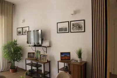 a living room with a tv on a wall at LE TRE CHIAVI Apartment in Palermo