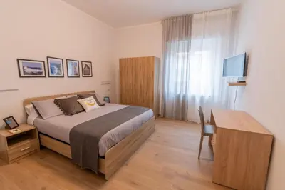 a bedroom with a bed and a desk and a television at LE TRE CHIAVI Apartment in Palermo