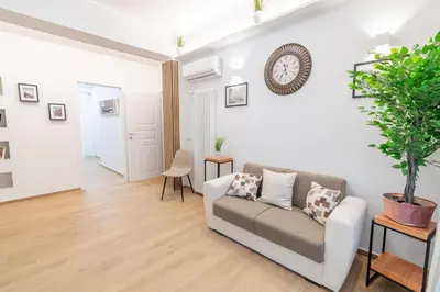 a living room with a couch and a clock on the wall at LE TRE CHIAVI Apartment in Palermo
