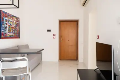 a living room with a couch and a wooden door at Casa M al Teatro Massimo in Palermo