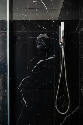 a black tiled shower with a hose in a bathroom at Casa M al Teatro Massimo in Palermo