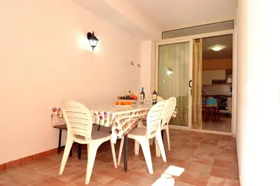 a dining room with a table with white chairs at case vacanze piccolo in Balestrate