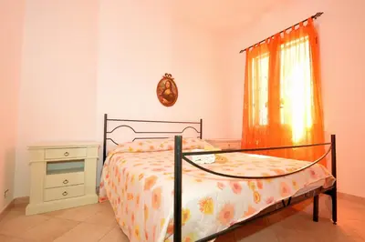 a bedroom with a bed and a dresser and a window at case vacanze piccolo in Balestrate