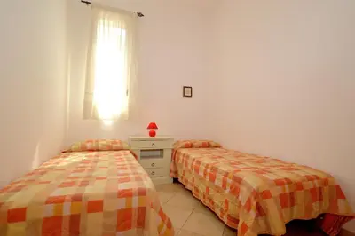 a bedroom with two beds and a window at case vacanze piccolo in Balestrate