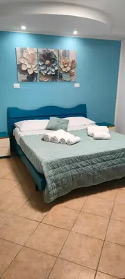 a bed in a blue room with towels on it at Sicily guest house in Palermo