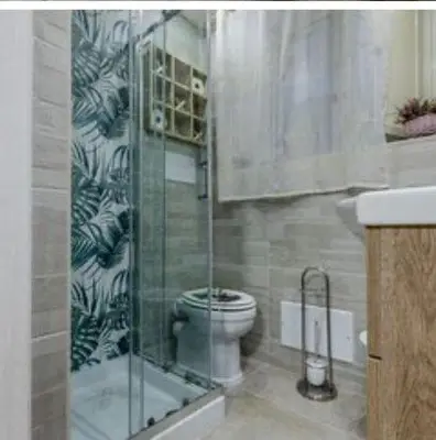 a bathroom with a toilet and a glass shower at Sicily guest house in Palermo