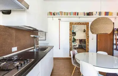 a kitchen with a sink and a table with chairs at Appartamento nel centro storico di Palermo in Palermo