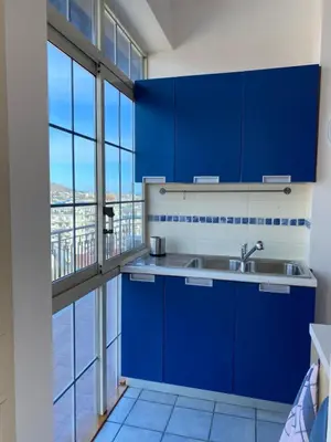 a kitchen with blue cabinets and a large window at MaDà holiday house ideale per coppie o famiglie in Palermo