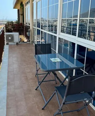 a glass table and chairs on a balcony at MaDà holiday house ideale per coppie o famiglie in Palermo