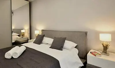 a bedroom with a large bed with white sheets and pillows at Holiday House Vitruvian in Terrasini