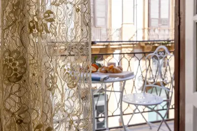 a patio with a table and chairs on a balcony at Verosicily Sant'Elia suite in Palermo